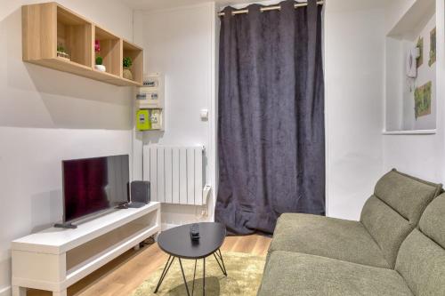 un salon avec un canapé et une télévision dans l'établissement Le Enzo joli F2 au coeur de Rouen, à Rouen