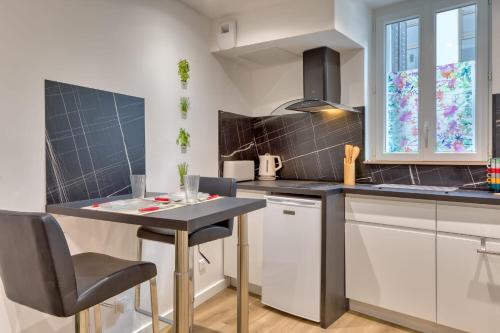 une cuisine avec une petite table et des chaises dans l'établissement Le Enzo joli F2 au coeur de Rouen, à Rouen