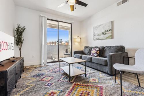 a living room with a couch and a tv at CozySuites Glendale - Westgate with pool 09 in Glendale