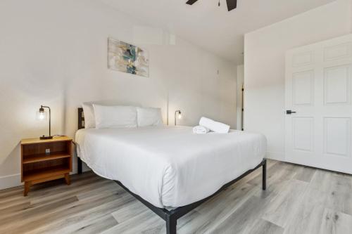 a bedroom with a large white bed and a wooden floor at CozySuites Glendale - Westgate with pool 09 in Glendale