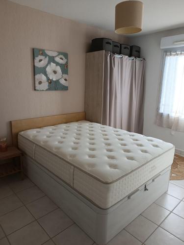 Ce lit se trouve dans un dortoir doté d'un matelas blanc. dans l'établissement Entre Terre et Mer, à Villeneuve-lès-Béziers