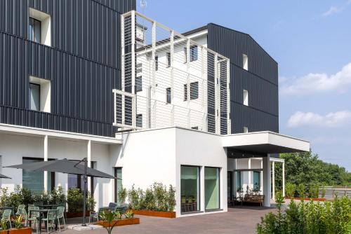 an external view of a building with a patio at Energy Park Hotel in Vimercate