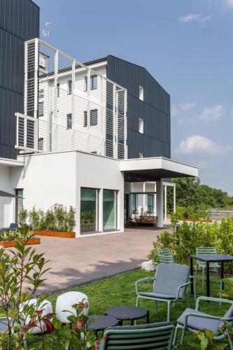 a building with chairs and tables in front of it at Energy Park Hotel in Vimercate