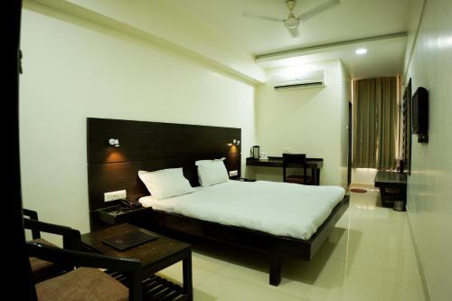 a bedroom with a bed and a desk and a chair at hotel sandhu palace in Jodhpur