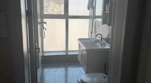 a bathroom with a sink and a toilet and a window at GreenTree Inn Weihai Liugongdao Wharf Qingdao North Road Express Hotel in Weihai