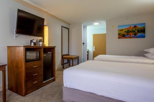 a bedroom with two beds and a flat screen tv at Arroyo Pinion Hotel, an Ascend Collection Hotel in Sedona