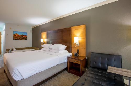 a hotel room with a large bed and a chair at Arroyo Pinion Hotel, an Ascend Collection Hotel in Sedona