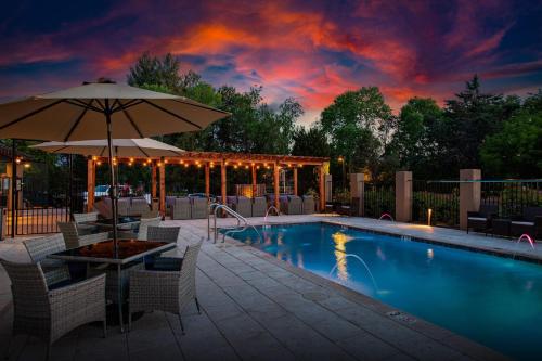 a swimming pool with an umbrella and chairs and a table with an umbrella at Arroyo Pinion Hotel, an Ascend Collection Hotel in Sedona