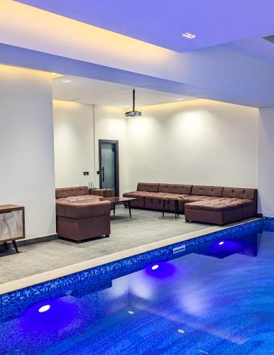 a room with a pool with couches and a swimming pool at The White Suites in Karachi