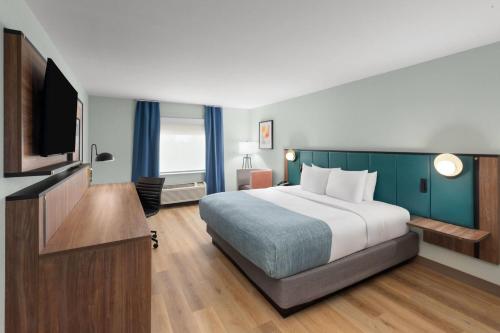 a hotel room with a bed and a flat screen tv at Wingate by Wyndham Augusta I-20 in Augusta