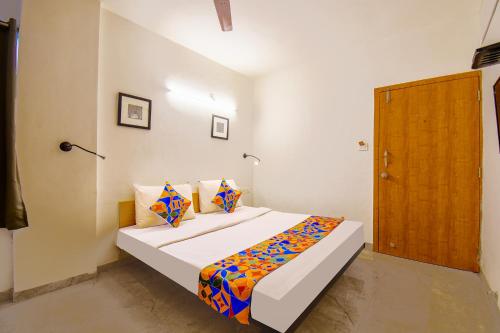 a bedroom with a bed and a wooden door at FabHotel Sai Raj - Nr Zeel College in Pune
