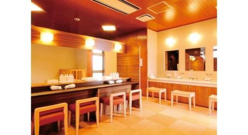 a large bathroom with a long table and chairs at Kyoto Keburikawa Hotel in Kameoka
