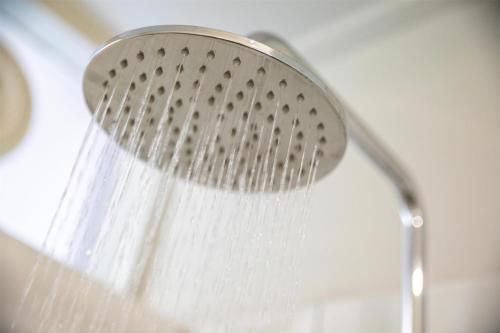 a shower head with water coming out of it at Nightcap at Keysborough Hotel in Keysborough