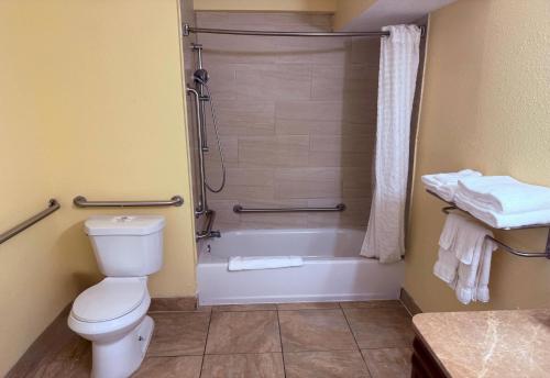 a bathroom with a shower and a toilet and a tub at Days Inn by Wyndham St. Petersburg / Tampa Bay Area in St Petersburg