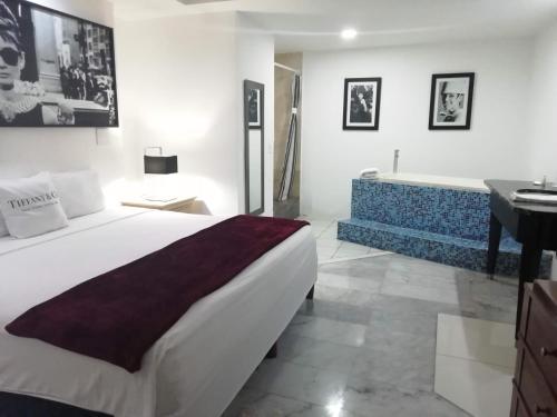 a bedroom with a large bed and a bath tub at Mayafair All Inclusive in Cancún