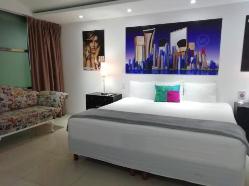a bedroom with a large white bed and a couch at Mayafair All Inclusive in Cancún