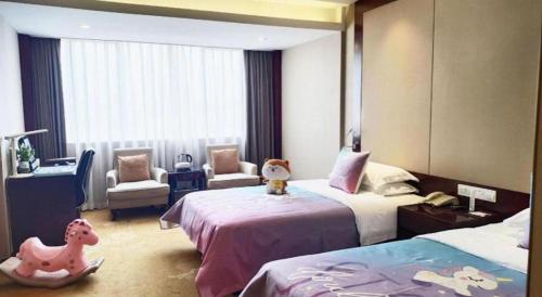 a bedroom with two beds and a room with two chairs at Quanzhou Overseas Chinese Hotel in Quanzhou