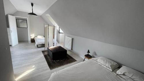 une chambre blanche avec un lit et une télévision dans l'établissement Mon Petit Cabourg, à Cabourg