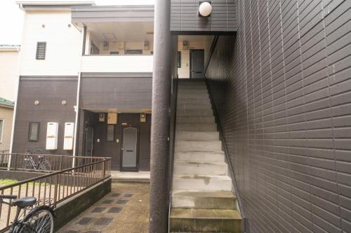 a stairway leading up to a building with a pole at 貝塚GoodStay in Fukuoka