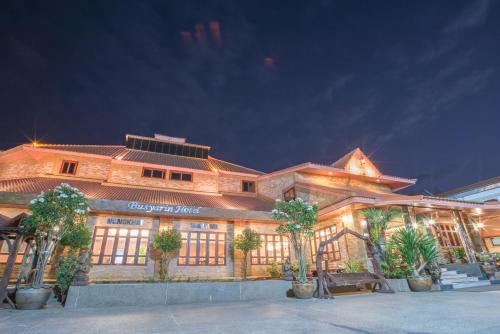 a large building with trees in front of it at Busyarin Hotel in Nong Khai