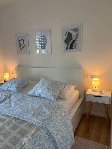 a bedroom with a bed and a nightstand with two lamps at Apartmán Wendy in Nové Město na Moravě