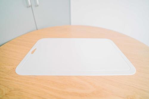 a white laptop sitting on top of a wooden table at 貝塚GoodStay in Fukuoka