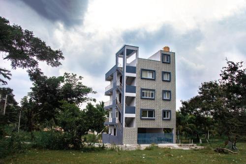 a tall building in the middle of a field at Vivaan Comforts in Bidadi