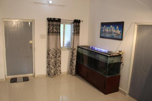 a living room with a fish tank and a window at DRZ Farm Stay with Private Pool 2BR by Homeyhuts 