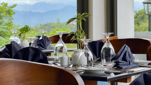 a table with plates and glass vases on it at Hasthi Boutique in Kandy