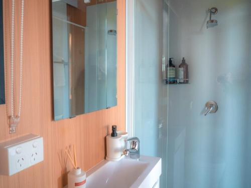 a bathroom with a sink and a mirror and a shower at Coleslea by Tiny Away in Leeton