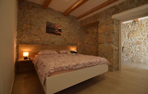 una camera da letto con un letto e un muro di pietra di Villa Elefant by Villas Guide a Tribalj