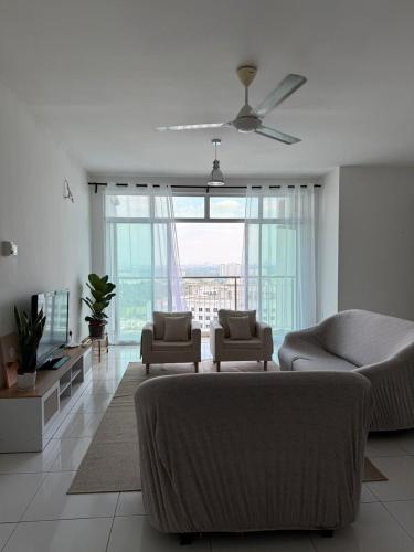 a living room with a couch and chairs and a large window at Spacious Flat with Breakfast Wifi 3 Free Parking at Seksyen 7 in Shah Alam