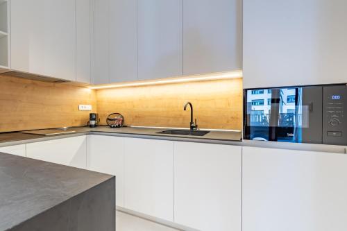 a kitchen with white cabinets and a microwave at Park Vila Apartments in Belgrade