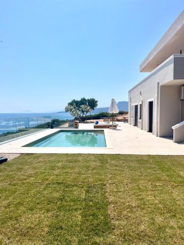a villa with a swimming pool and a yard at SeaWave Villas, By Hellocrete in Chania Town