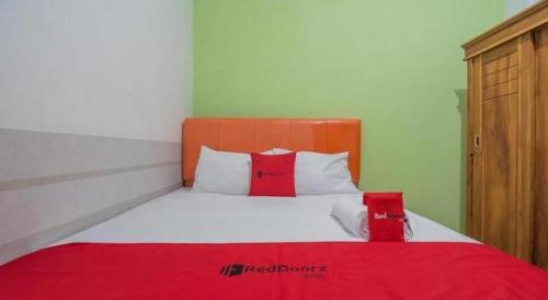 a bedroom with a large bed with a red blanket at OYO Life 92127 Skyland Pasteur in Bandung
