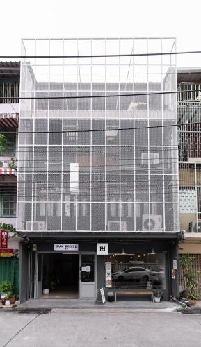 a large glass building with a car in it at Siam Breeze Inn - Self Check-in in Bangkok