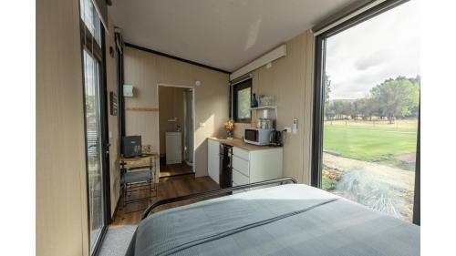 a bedroom with a bed and a large window at Matakanui Retreat 1 by Tiny Away in Omakau