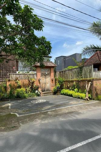 a house on a street with a fence at Budha House Ubud in Ubud