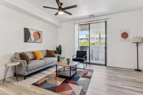 グレンデールにあるCozySuites Glendale - Westgate w pool 16のソファと天井ファンのあるリビングルーム