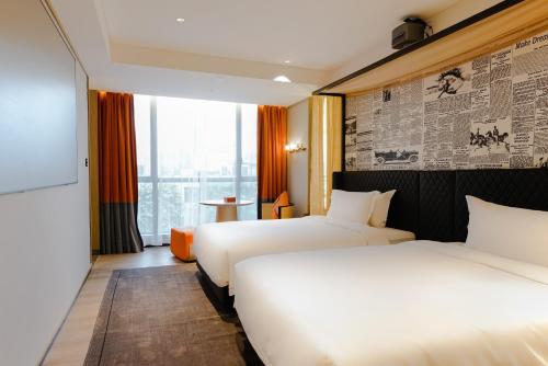 广州Arthur Hotel Baiyun Guangzhou的有两张床和一扇窗户的酒店房间