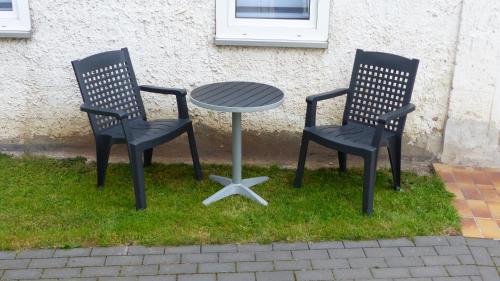 two chairs and a table in the grass at Haus am Bahndamm in Holzminden