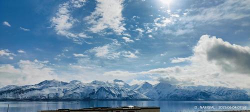 a view of a mountain range with the sun in the sky at Mystic Pangong in Spangmik
