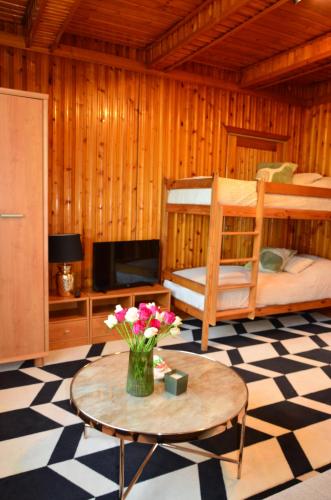 a room with two bunk beds and a table with flowers at Antoniówka in Zakopane