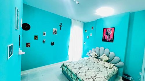 a blue bedroom with a bed with a blue wall at Shabiya homes in Abu Dhabi