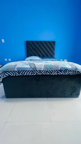 a bed in a room with a blue wall at Shabiya homes in Abu Dhabi