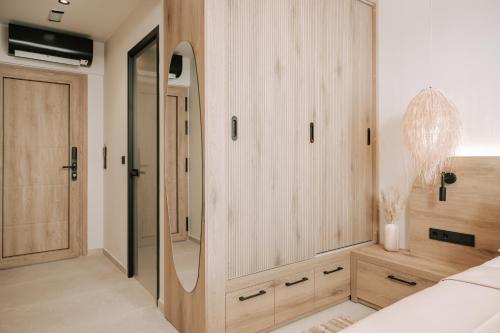 a bedroom with a large mirror and a dressing room at La Brise Luxury Suites in Néa Péramos