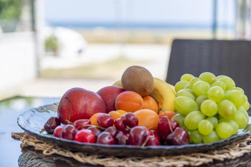 a plate of fruit on top of a table at Mitro Seaview Apartments in Nea Vrasna