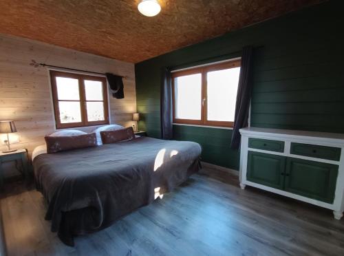 una camera da letto con un letto con pareti e finestre verdi di Au Marais ad Amiens