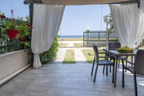 a patio with a table and chairs and a view of the ocean at Mitro Seaview Apartments in Nea Vrasna