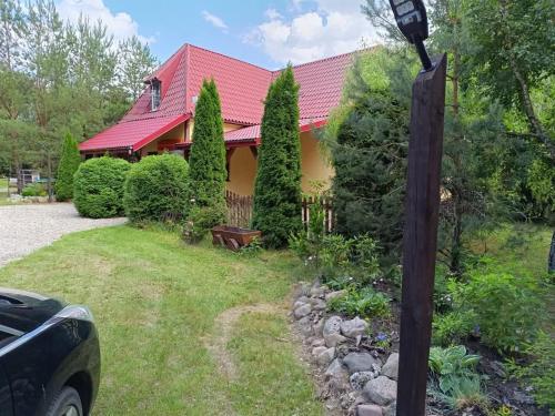 a house with a red roof and a yard at Gospodarstwo Agroturystyczne na Mazurach in Jerutki